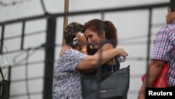 Workers react as they knew their co-worker Nuria Karina Campos died at the Finance Ministry building during a blaze in San Salvador, El Salvador, July 7, 2017.