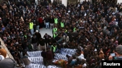 People and family members gather to identify the bodies of their relatives, who were coal miners from Pakistan's minority Shi'ite Hazara community and got killed by unidentifyed persons in Mach area of Bolan district, in Quetta, Pakistan, Jan, 3, 2021.