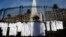 FILE - White medical coats hanging from the iron gate that surrounds the national monument May Pyramid, as a symbolic act against efforts to legalize abortion, in Buenos Aires, Argentina, July 15, 2018.