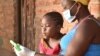 Une élève travaille avec sa mère sur un cours à l'aide d'une tablette fournie par l'organisation caritative britannique Voluntary Services Overseas, au Malawi. (VSO / Craig Mawanga)