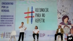 ARCHIVO - Carmenza Gómez (izq), y Gloria Martínez (cent), familiares de asesinados mediante ejecución extrajudicial en 2008, asisten a un evento de reconciliación con el general retirado Paulino Coronado (der), en Soacha, Colombia, el 10 de mayo de 2022.