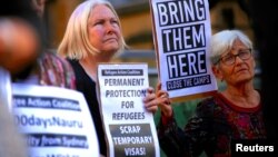 FILE - Refugee advocates hold placards and banners during a protest in central Sydney, Australia, Oct. 5, 2016, calling for the closure of the Australian detention centers in Nauru and Manus Island.