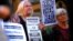 FILE - Refugee advocates hold placards and banners during a protest in central Sydney, Australia, Oct. 5, 2016, calling for the closure of the Australian detention centers in Nauru and Manus Island.