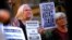FILE - Refugee advocates hold placards and banners during a protest in central Sydney, Australia, Oct. 5, 2016, calling for the closure of the Australian-run detention centers in Nauru and Manus Island. A similar rally took place in Melbourne Saturday.