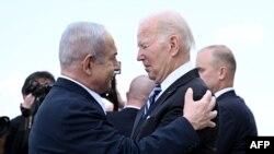(ARQUIVO) Primeiro-ministro de Israel, Benjamin Netanyahu (à esquerda), cumprimenta o Presidente dos EUA, Joe Biden, à sua chegada ao aeroporto Ben Gurion de Telavive, em 18 de outubro de 2023, no meio das batalhas em curso entre Israel e o grupo palestiniano Hamas.