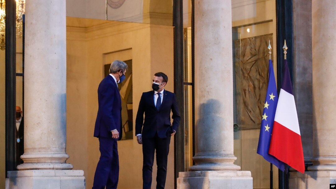 United States Special Presidential Envoy for Climate John Kerry, who traveled to Paris to relaunch transatlantic cooperation with European officials, speaks with France's President Emmanuel Macron after a meeting, March 10, 2021,