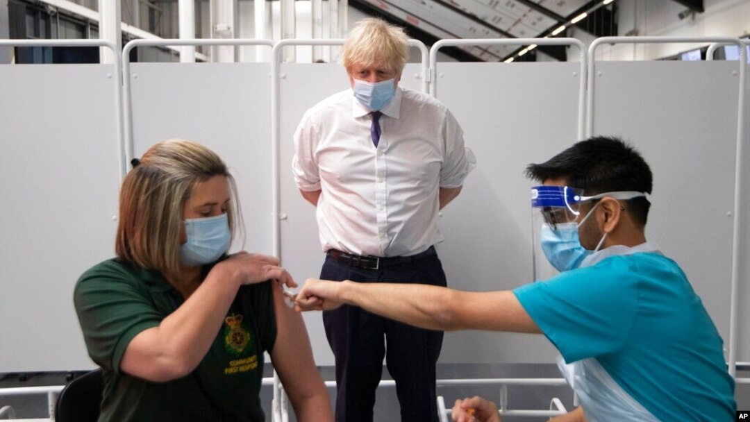 Perdana Menteri Inggris Boris Johnson menyaksikan seorang petugas tanggap darurat menerima vaksinasi Covid-19 di Bristol, Inggris (11/1).