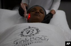 FILE —A specialized light treatment is applied to enhance product absorption before the application of a skin lightening product at the Skin and Body International Centre in Lenasia, Johannesburg, July 7, 2020