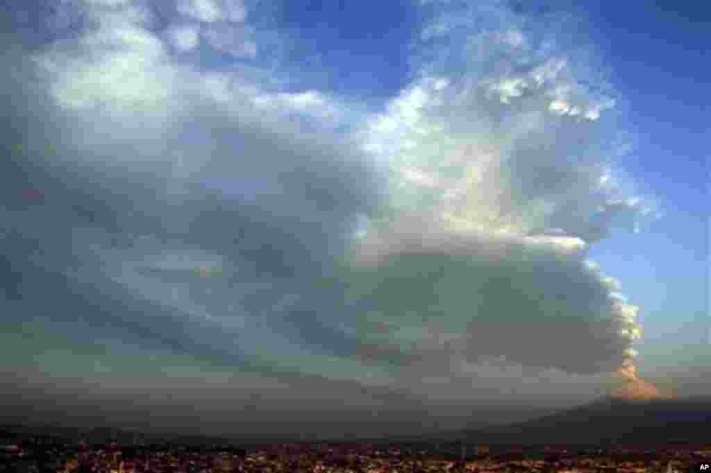 A plume of ash and steam rise from Popocatepetl volcano seen from San Andres Cholula, Mexico, Wednesday April 18, 2012. Mexico's Popocatepetl volcano is continuing to spout gases and hot rock fragments and it is dusting towns on its flanks with volcanic a