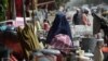 This photo taken on September 12, 2021 shows a woman looking at secondhand household items for sale at a market in the northwest neighbourhood of Khair Khana in Kabul.