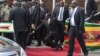 Zimbabwean President Robert Mugabe, center, falls after addressing supporters upon his return from an African Union meeting in Ethiopia, Wednesday, Feb. 4, 2015. Mugabe, 90, was elected chairman of the African Union and is set to celebrate his 91st birthday on Feb. 21. (AP Photo)