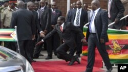 Zimbabwean President Robert Mugabe, center, falls after addressing supporters upon his return from an African Union meeting in Ethiopia, Wednesday, Feb. 4, 2015. Mugabe, 90, was elected chairman of the African Union and is set to celebrate his 91st birthday on Feb. 21. (AP Photo)