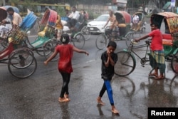 Anak-anak menikmati percikan air yang ditembakan meriam air oleh Dhaka North City Corporation untuk meredam gelombang panas di Dhaka, Bangladesh, Sabtu, 28 April 2024. (Foto: Mohammad Ponir Hossain/Reuters)