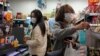 People wear protective face masks as they make purchases from a convenience store in Hong Kong, Monday, Feb, 3, 2020. 