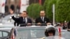 Morocco's King Mohammed VI, right, and French President Emmanuel Macron wave to crowds during the latter's official visit to Morocco, in Rabat, Oct. 28, 2024.