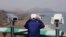 A South Korean tourist uses binocular to look at the Diamond Mountain in North Korea from the Unification Observation post in Goseong, South Korea, April 7, 2017.