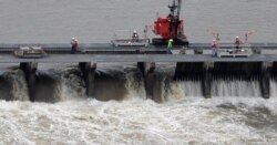 FILE - Workers open bays of the Bonnet Carre Spillway, to divert rising water from the Mississippi River to Lake Pontchartrain, upriver from New Orleans, in Norco, La., May 10, 2019.