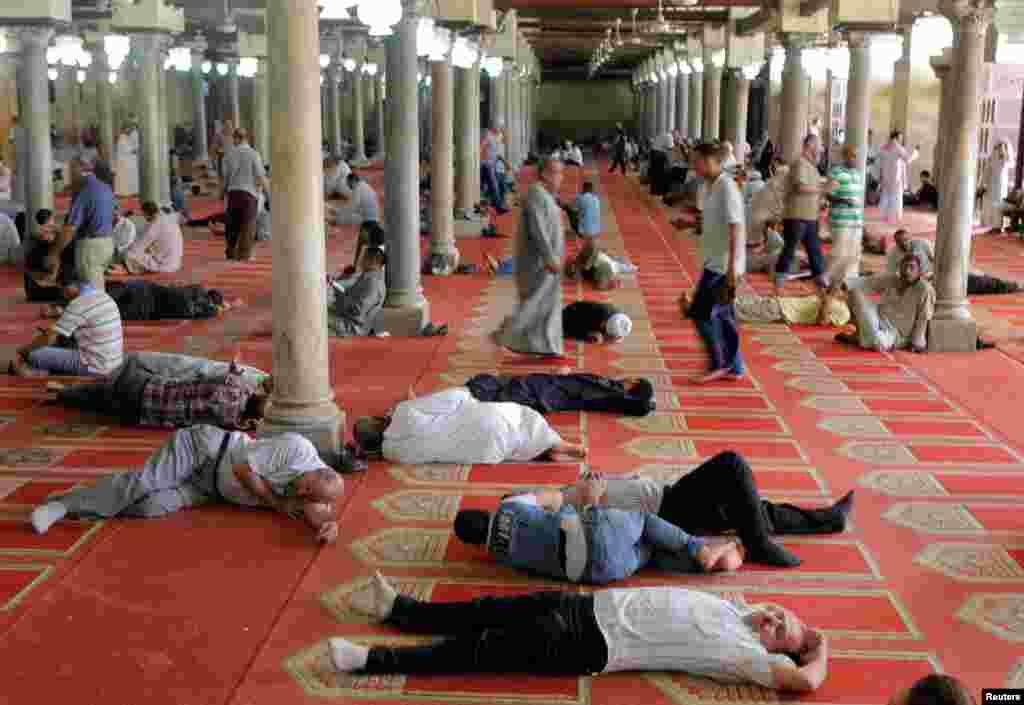 Egyptian Muslims rest after the Friday prayer at Al Azhar mosque in Cairo.