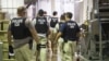 FILE - Immigration and Customs Enforcement (ICE) together with Homeland Security Investigations (HSI) officers prepare to make arrests at an agricultural processing facility in Canton, Mississippi, Aug. 7, 2019.
