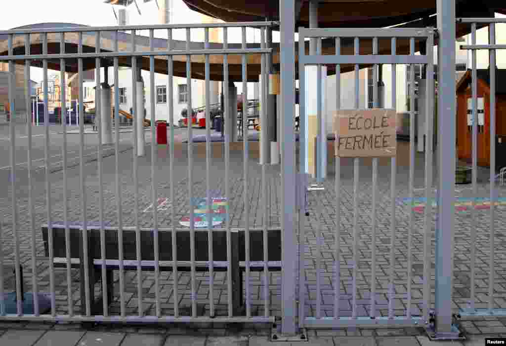 Papan bertuliskan &quot;sekolah ditutup&quot; di depan pintu gerbang sebuah sekolah dasar dan taman kanak-kanak di Brussels (23/11), menyusul pengetatan keamanan di Brussels setelah serangan-serangan fatal di Paris. (Reuters/Francois Lenoir)