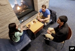In this Feb. 24, 2015 photo, Vivek Shah, right, a sophomore resident advisor at Vanderbilt University, talks with friends Samara Lieberman, left, a senior from Detroit, and Tyler Shull, center, a sophomore from Chapel Hill, NC, by a fireplace in the great room in the Warren College and Moore College section of the Vanderbilt campus in Nashville, Tenn. (AP Photo/Mark Humphrey)