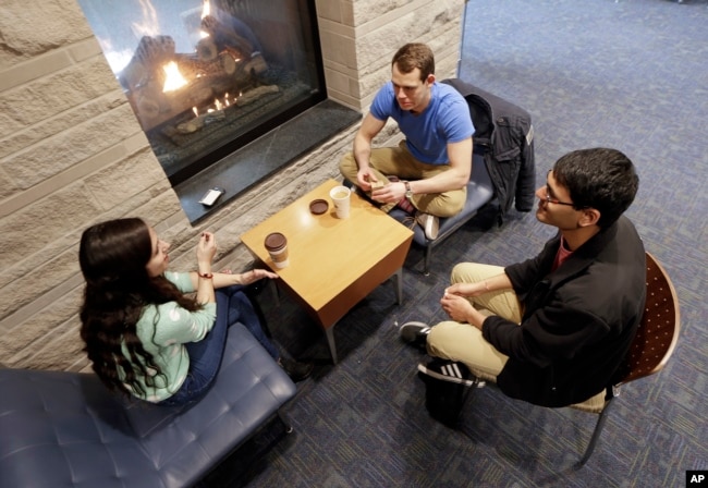 In this Feb. 24, 2015 photo, Vivek Shah, right, a sophomore resident advisor at Vanderbilt University, talks with friends Samara Lieberman, left, a senior from Detroit, and Tyler Shull, center, a sophomore from Chapel Hill, NC, by a fireplace in the great room in the Warren College and Moore College section of the Vanderbilt campus in Nashville, Tenn. (AP Photo/Mark Humphrey)