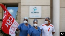 Employees demonstrating outside a nursing home of the Korian group, one of the market leaders in the lucrative industry of providing care and assisted living facilities for older adults, May 25, 2020 in Paris. 