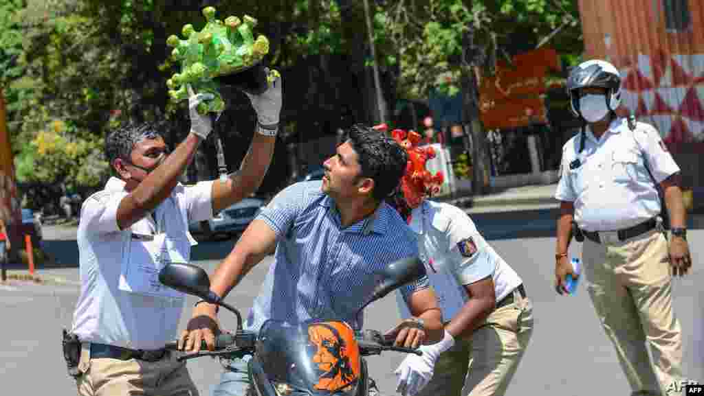 전국 봉쇄령이 내려진 인도 방가로르에서 경찰이 시민을 상대로 신종 코로나바이러스를 형상화한 헬멧을 이용해 바이러스에 대해 교육하고 있다.