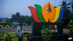 An Indian policeman from bomb squad checks a roundabout with a huge BRICS logo, in Goa, Oct. 14, 2016.