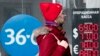 RUSSIA -- A woman walks past an exchange office screen showing the currency exchange rates of U.S. Dollar and Euro to Russian Rublel in Moscow, March 9, 2020