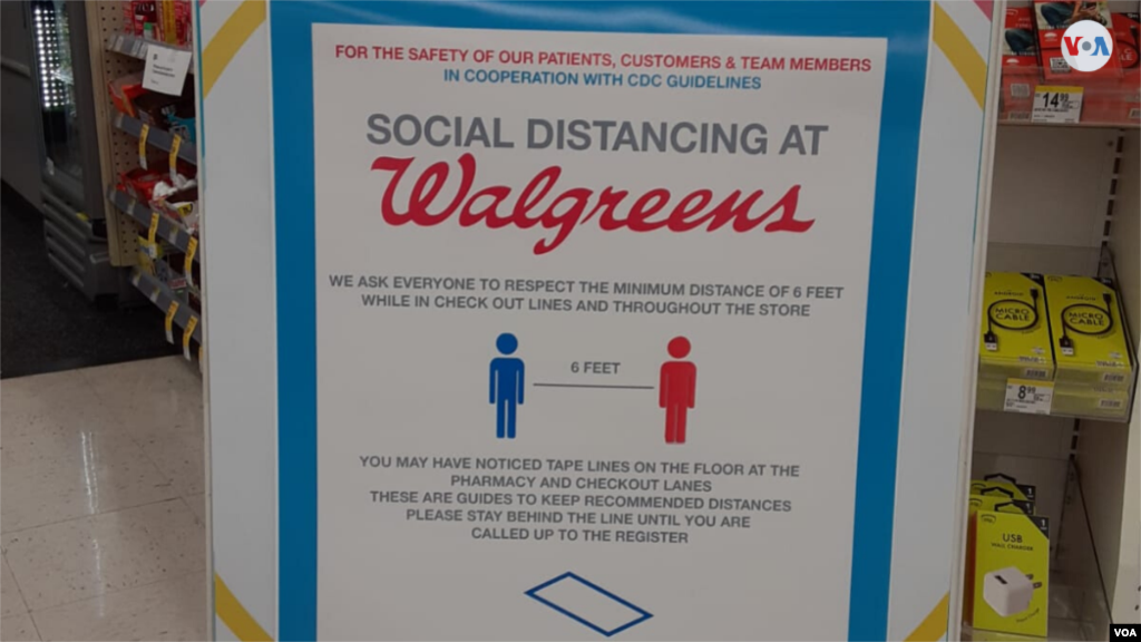 Un rótulo en una farmacia de la cadena Wallgreens recuerda a sus clientes la distancia que deben guardar entre sí, que en Estados Unidos se ha establecido de 6 pies, el equivalente a casi 2 metros. [Foto: Mitzi Macías]