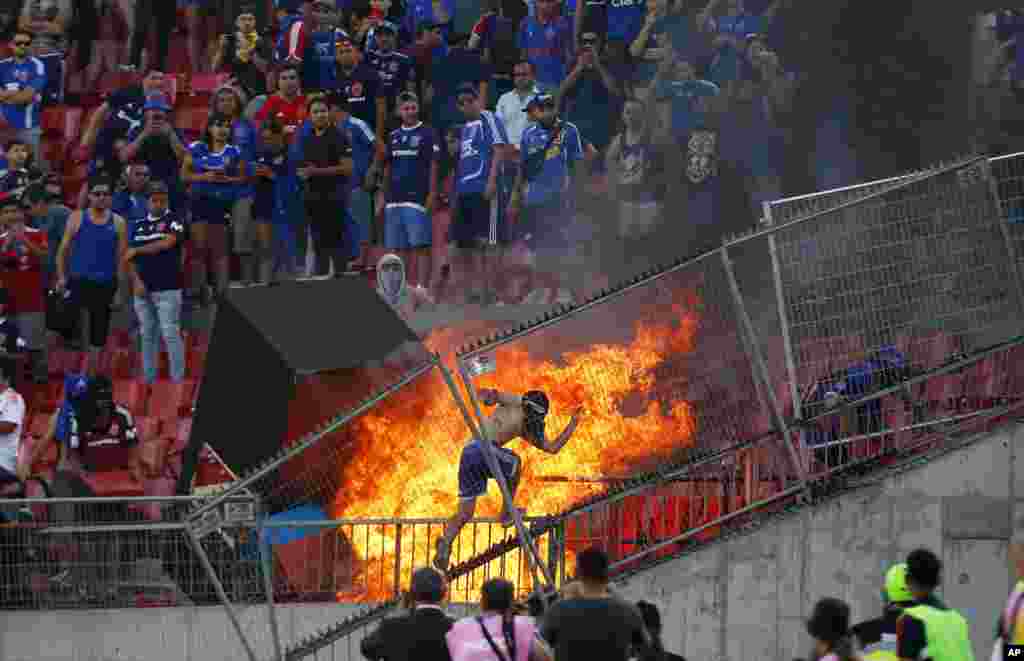 A small group of anti-government protesters set a section of the stadium on fire during the Copa Libertadores soccer game between Universidad de Chile and Brazil&#39;s SC Internacional, in Santiago, Chile, Feb. 4, 2020.