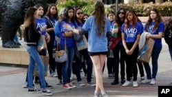 FILE - In this Feb. 26, 2015, file photo, UCLA campus tour guide Samantha St. Germain, center, a bioengineering student, leads prospective college-bound high school seniors on a campus tour in Los Angeles. 