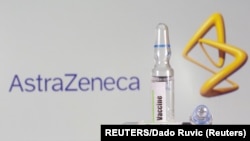 A test tube labeled with the vaccine is seen in front of AstraZeneca logo