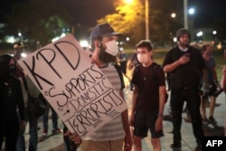FILE - Demonstrators protests the shooting of Jacob Blake in Kenosha, Wisconsin, Aug. 26, 2020.