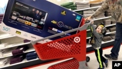 FILE - Hunter Harvey and his dad, C.J., plan to purchase a big screen TV at Target, in Wilmington, Massachusetts, Nov. 25, 2016. The U.S. Commerce Department reported Tuesday, Nov. 29, 2016, that the economy grew faster than expected between July and Sept