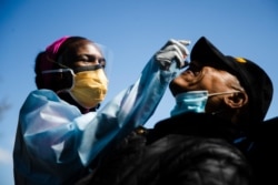 Dr. Ala Stanford administers a COVID-19 swab test on Wade Jeffries in the parking lot of Pinn Memorial Baptist Church in Philadelphia, April 22, 2020.