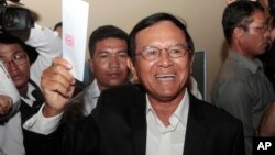 Opposition Cambodia National Rescue Party President Kem Sokha shows off his ballot before voting in local elections in Chak Angre Leu on the outskirts of Phnom Penh, Cambodia, Sunday, June 4, 2017. (AP Photo/Heng Sinith)