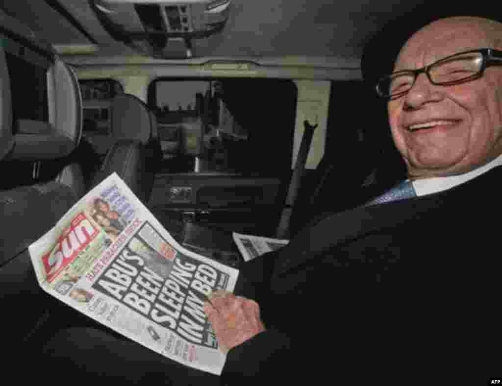 News Corp. chief executive Rupert Murdoch, reads his group's The Sun daily newspaper, as he is driven from his home, in central London, Friday, Feb. 17, 2012. Murdoch is meeting with his British newspaper staff amid police inquiries into alleged misconduc