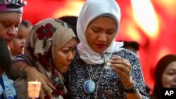 Norazlinda Ayub, left, and Intan Maizura Othaman, wife of an air crew member of Malaysia Airlines Flight 370, embrace each other during the Day of Remembrance for MH370 event in Kuala Lumpur, Malaysia, March 3, 2019.
