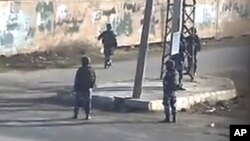 In this image taken from amateur video made available by Sham News Network in Syria on Dec. 13, 2011, shows pro-government militia on the street in Daraa, Syria.