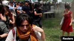 Turkish riot policeman uses tear gas as people protest destruction of trees in a park brought about by a pedestrian project, Taksim Square, Istanbul, May 28, 2013.