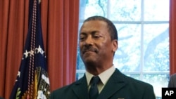 FILE - In this July 10, 2015, file photo Randy Moore, of the U.S. Forest Service, listens as President Barack Obama talks about the designation of three new national monuments in the Oval Office of the White House in Washington.