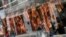 Pedestrians are reflected in the storefront window of a Chinese restaurant displaying roasted duck in downtown Lima, Peru, July 11, 2020, amid the new coronavirus pandemic.