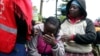 Anggota Palang Merah Kenya dan para kerabat menghibur seorang perempuan yag menangis di dekat asrama sekolah yang terbakar di SD Hillside Endarasha, di Nyeri, Kenya, 6 September 2024. (Foto: AP Photo)