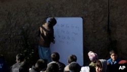 Afghan refugee schoolchildren attend a class at a makeshift school on the outskirts of Islamabad, Pakistan, Dec. 29, 2021. 