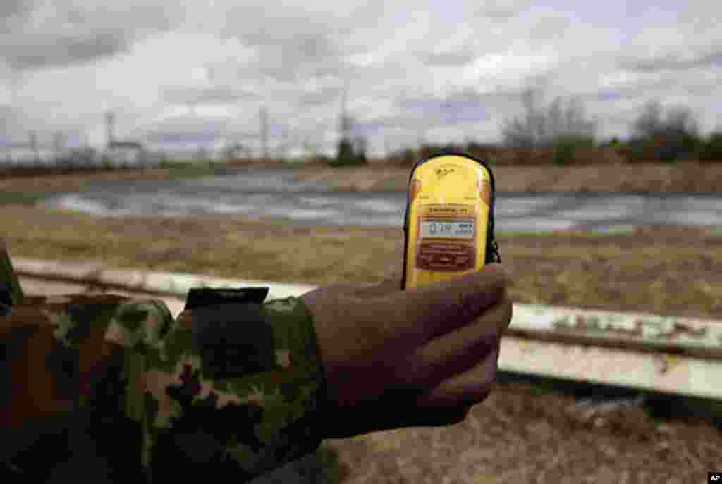 A tour guide measures radiation at the site of Chernobyl. (VOA Photo/D. Markosian)