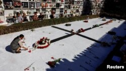 Una mujer coloca claveles ante un monumento a los republicanos asesinados durante y después de la Guerra Civil Española (1936-1939), en un cementerio durante el Día de Todos los Santos, en Ronda, España, el 1 de noviembre de 2022.