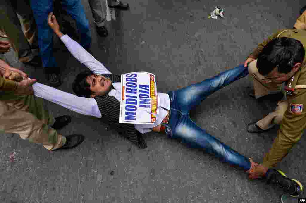 An Indian supporter of the Congress Party shout slogans as police detain him during a protest against billionaire jeweller Nirav Modi in New Delhi.