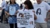 Reanta Grattani, who claims to be a friend of the Orlandi family, center, holds a t-shirt with the pictures of Emanuela Orlandi and Pope Francis outside the Vatican, Saturday, July 20, 2019. 